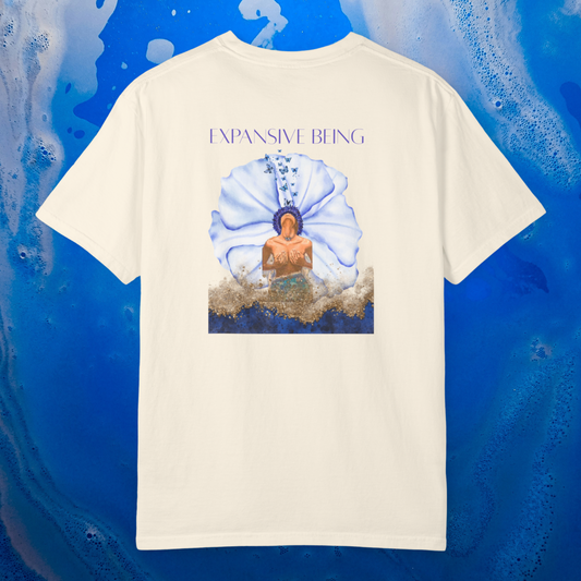 a white ivory color t-shirt spiritually designed to heal the throat chakra the design graphic is a women in a blue flower she breathe out butterflies the color is blue gold ligh blue and orange the t-shirt is 100% cotton premium quality high vibrational clothing line. the background is ocean blue soft