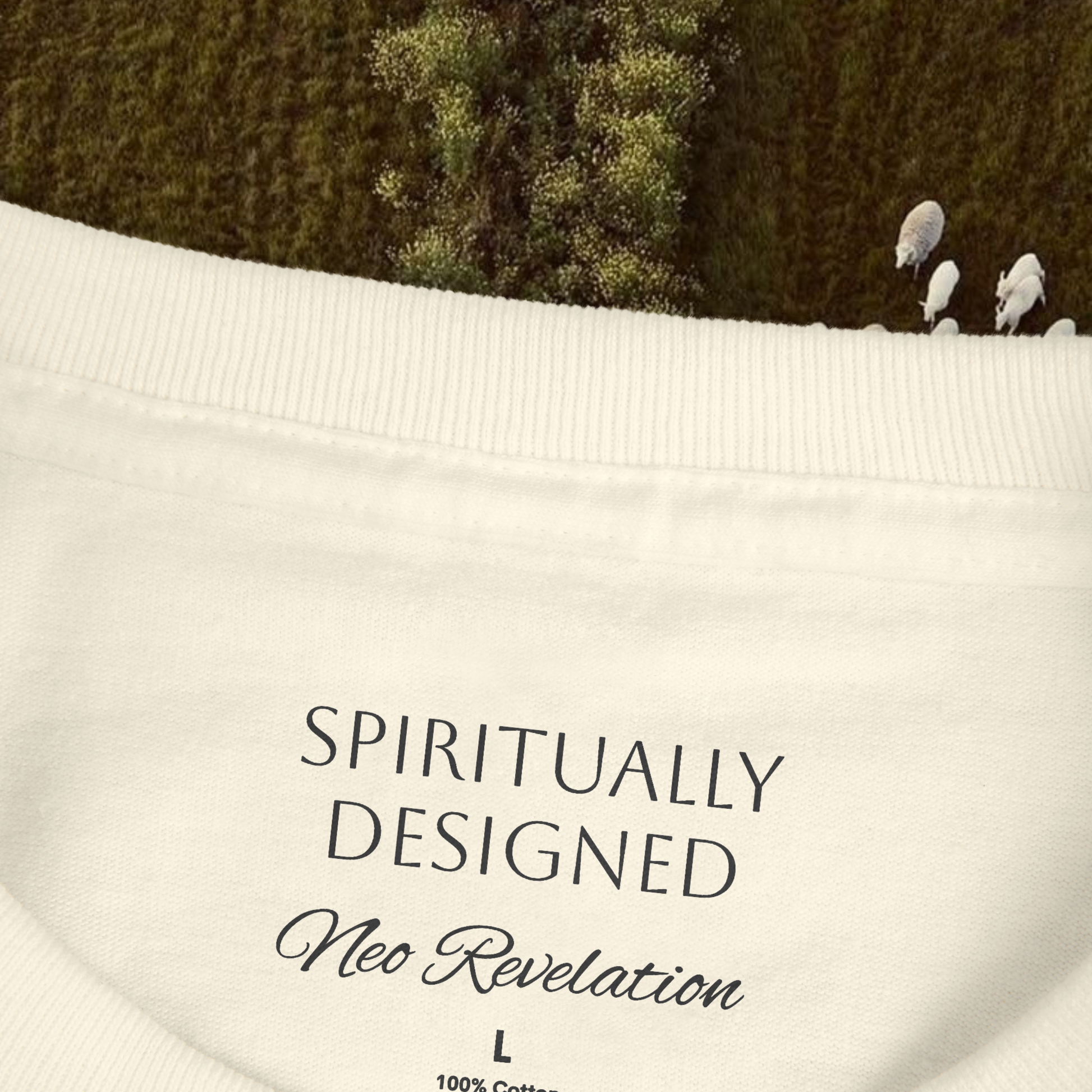 zoom view on the necklabel of a white cotton t-shirt unisex written 'spiritually designed' and 'neo revelation' in black  on a nature green background with sheeps